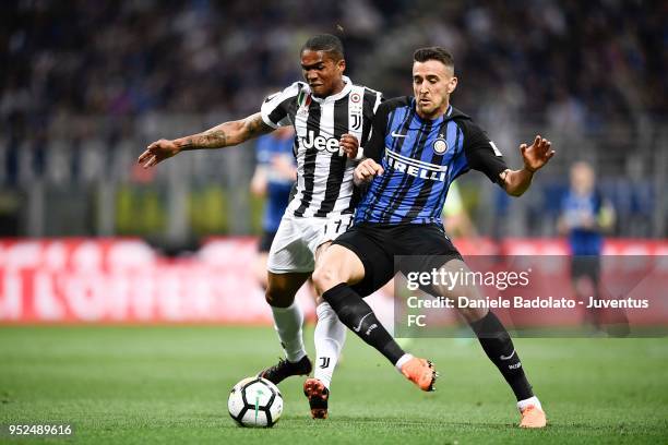 Alex Sandro of Juventus competes for the ball with Matias Vecino of FC Internazionale during the serie A match between FC Internazionale and Juventus...