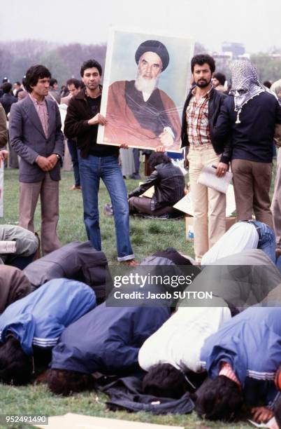 Des manifestants affichent leur soutien à l'Ayatollah iranien Khomeiny lors de la guerre entre l'Iran et l'Irak et font leur prière vers La Mecque en...