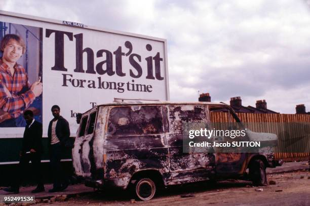 Camionnette incendiée à Brixton devant un panneau de contestation de la politique d'austérité de Margaret Thatcher, Premier ministre britannique, en...