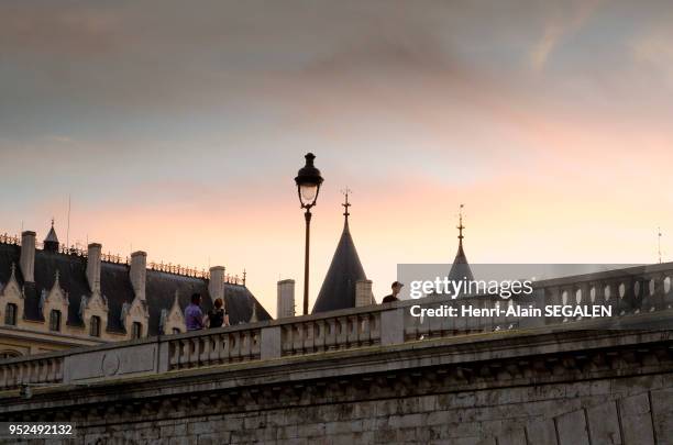Lumière crepusculaire de fin de journée sur le Pont au Change, et toitures de la Conciergerie, Paris, France.