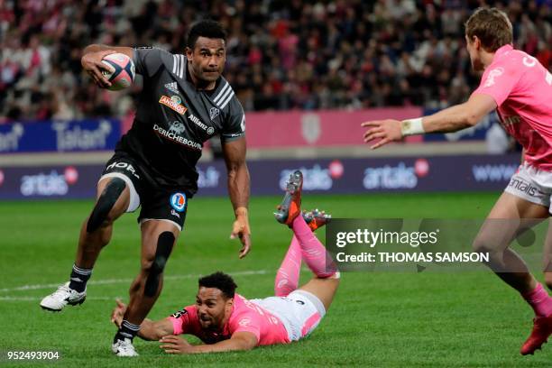 Brive's Fijian centre Seremaia Burotu runs with the ball and avoids a tackle during the French Top 14 rugby union match between Paris Stade Francais...