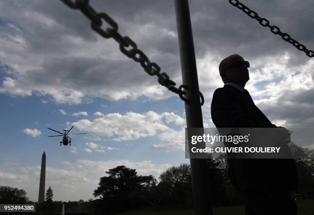 President Donald Trump onboard Marine One departs from the White House, as a Secret Service agent stands guard on April 28, 2018 in Washington, DC....