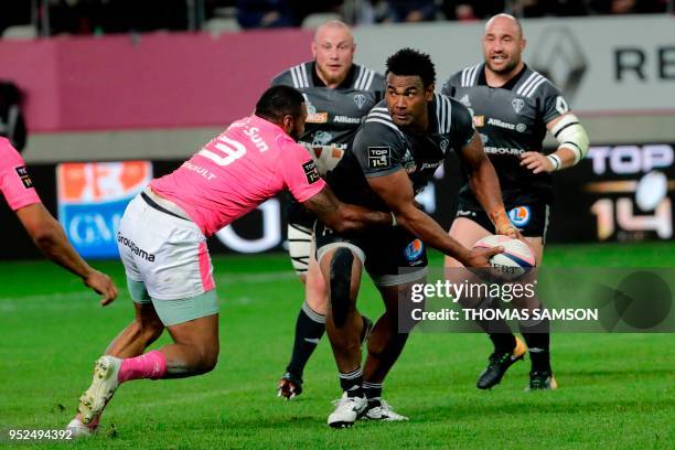 Brive's Fijian centre Seremaia Burotu passes the ball as he is tackled by Stade Francais' Fijian winger Waisea Nayacalevu during the French Top 14...