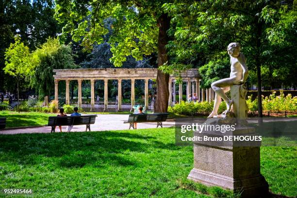 Le bassin ovale de la naumachie avec sa colonnade, la statue 'Le Jeune Faune' par Félix Charpentier dans le Parc Monceau à Paris, France.