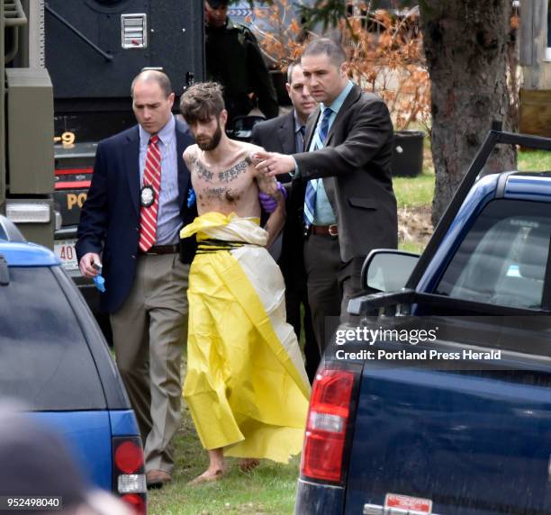 Suspect John Williams is led by Maine State Police detectives into a cruiser at 807 Route 139 in Fairfield after he was apprehended Saturday, April...