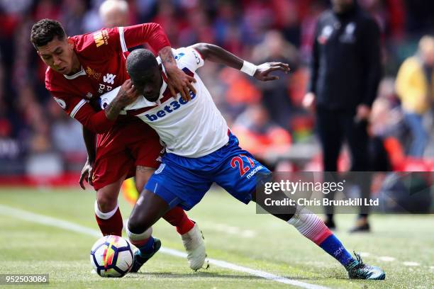 Badou Ndiaye of Stoke City is challenged by Roberto Firmino of Liverpool during the Premier League match between Liverpool and Stoke City at Anfield...