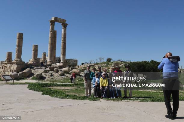 Tourists pose for a photo in front of the Temple of Hercules, a Roman temple that was built in 162-66 AD, as they visit the Amman Citadel in the...