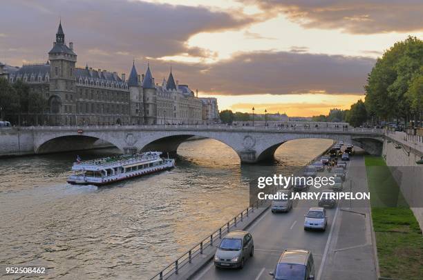 The expressway on the right bank and the Pont au Change bridge on Seine river with a cruise boat. In the background the Cite, the Conciergerie and...