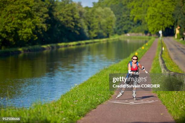 Femme faisant du roller le long du canal de la Marne au Rhin, Alsace.