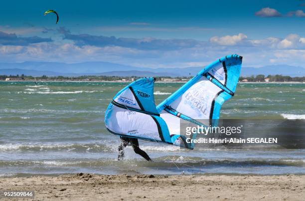 Skysurfer, ou kitesurfer, portant son cerf-volant sur la plage Nord, Le-Grau-du-Roi, Gard, France.