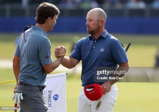 Kevin Kisner and Scott Brown shake hands as they finish their round on the 18th green during the third round of the Zurich Classic at TPC Louisiana...