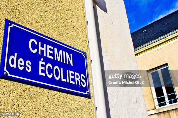 Plaque sur un mur qui indique le nom du chemin des ecoliers, Connerre, Sarthe, France.