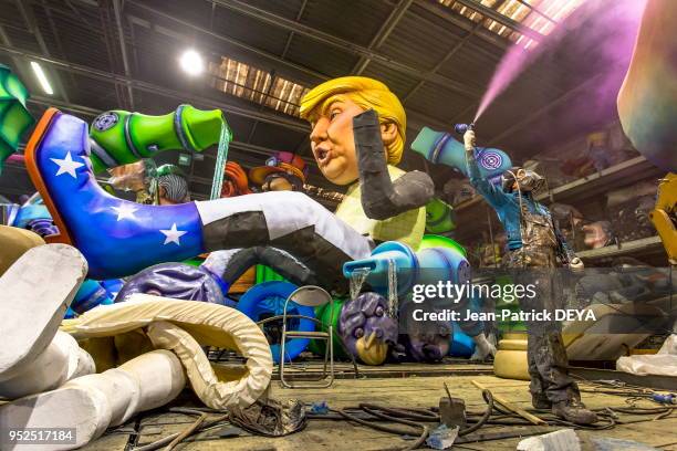 Représentation de Donald Trump et ouvrier peignant à l'aide d'un pistolet de peintre, atelier du carnaval de Nice, février 2017, France.