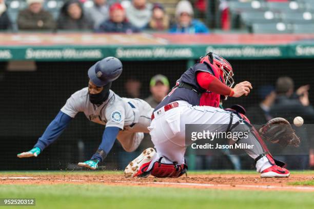 Dee Gordon of the Seattle Mariners scores during the fourth inning as catcher Roberto Perez of the Cleveland Indians tries to make the tag at...