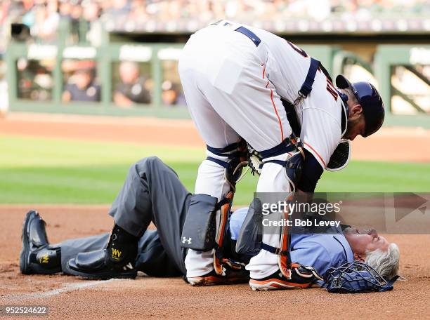 Home plate umpire Tom Hallion is checked on by Brian McCann of the Houston Astros after he was hit by a ball in the first inning at Minute Maid Park...