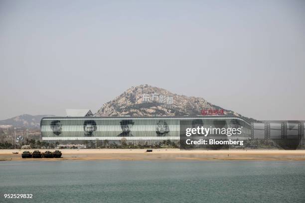 Commercial complex covered with giant portraits of movie stars on its facade stands at the Dalian Wanda Group Co. Oriental Movie Metropolis film...