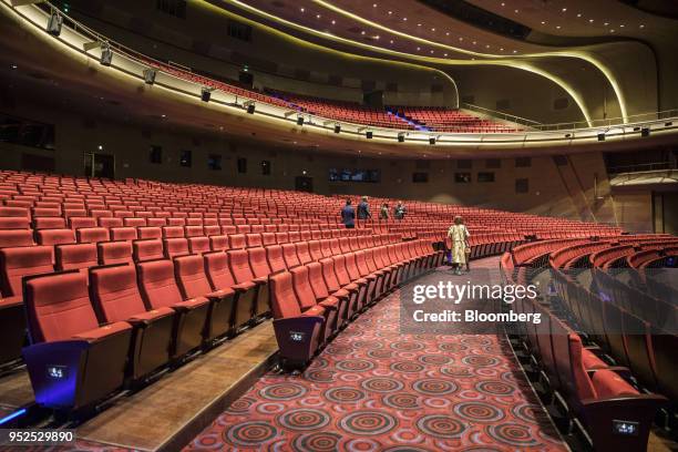 People walk past seats at the Grand Theater at the Dalian Wanda Group Co. Oriental Movie Metropolis film production hub in Qingdao, China, on...