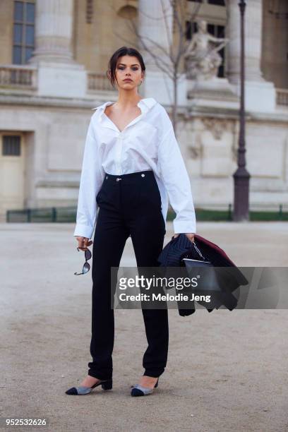 New Zealand model Georgia Fowler wears a white Balenciaga shirt with an open collar, black pants, and a black Celine bag after the Elie Saab show at...