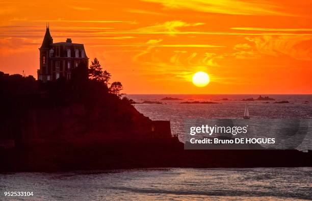 Coucher de soleil sur la villa 'Les roches brunes' construite entre 1893 et 1896 à la pointe de la Malouine sur la Côte d'Emeraude. Elle appartient...