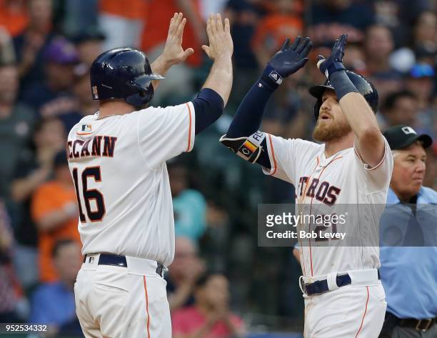 Derek Fisher of the Houston Astros receives a high five from Brian McCann after hitting a two-run home run in the fourth inning against the Oakland...