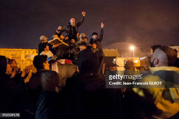 Groupe de migrants levant le point en l'air le 11 avril 2016 dans le camp de réfugiés de Grande-Synthe en banlieue de Dunkerque, France.