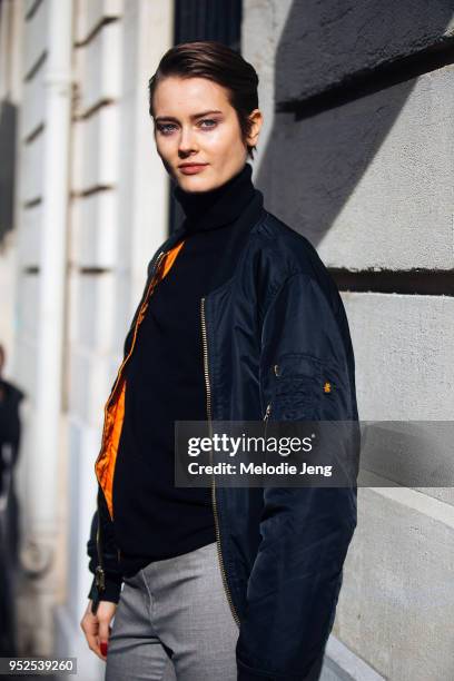 Model Jac Jagaciak wears a black Alpha Industries MA1 bomber jacket, black turtleneck, and gray pants on March 02, 2018 in Paris, France.