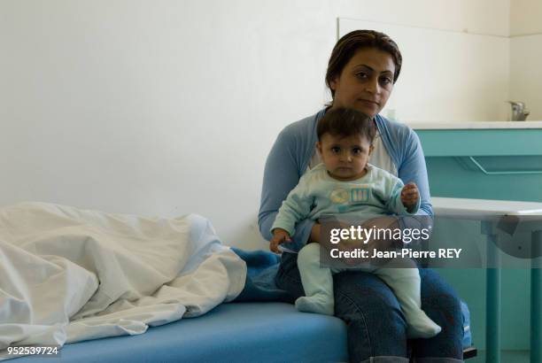 Une jeune maman irakienne avec son bébé en zone d'attente le 8 septembre 2006, France.