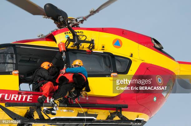 Secouriste hélitreuillé avec son chien à bord d'un hélicopère de la Securité Civile 4 mars 2012, Alpe d'Huez, France.