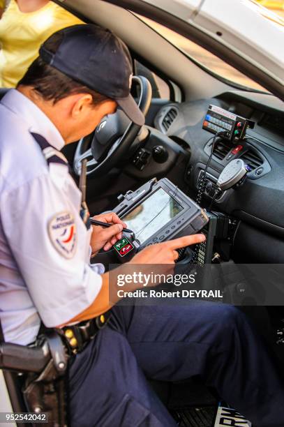 Policier utilisant un équipement informatique embarqué permettant l'identification des véhicules et des personnes dans la circulation le 6 octobre...