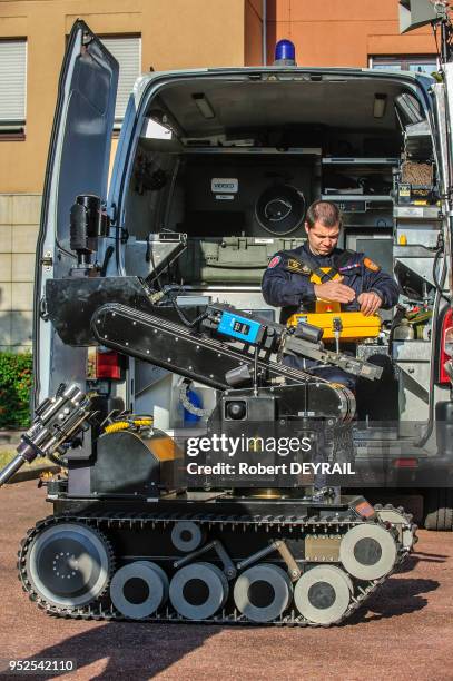 Policiers contrôlant un robot à distance lors d'une démonstration d'une équipe pyrotechnique de la police chargée du déminage le 6 octobre 2012 à...