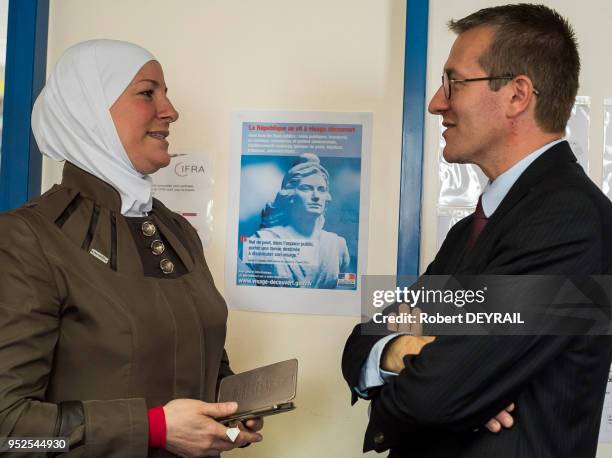 Une éléve échange devant une photographie de 'Marianne' avec Denis Bruel, secre?taire ge?ne?ral adjoint de la pre?fecture au centre de formation...