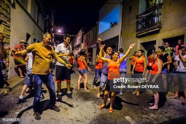 Groupe d'hommes et femmes chantant et dansant lors de la traditionnelle traversée des taureaux des arènes à travers les ruelles, 1et août 2015,...