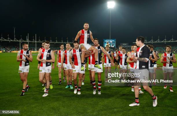Sam Gilbert of the Saints is chaired from the field after his 200th match by teammates Nathan Brown and Tom Hickey during the 2018 AFL round six...