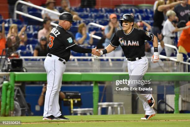 Derek Dietrich of the Miami Marlins sheiks hands with Third Base Coach Fredi Gonzalez after hitting a home run in the seventh inning against the...