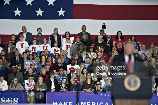 Attendees listen as U.S. President Donald Trump speaks during a rally in Washington, Michigan, U.S., on Saturday, April 28, 2018. Trump took on most...