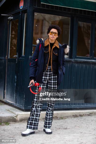 Model Lineisy Montero wears orange-frame retro sunglasses, a blue Anorak, a Coach shearling-lined denim jacket, black and white plaid pants, white...