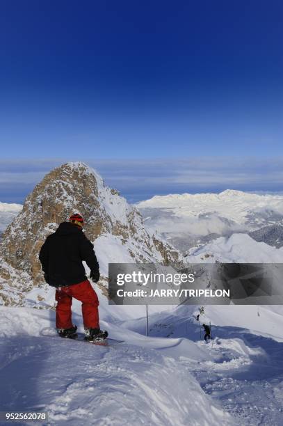 Snowboarder at the start of black difficult ski slope from the top of Saulire mountain, Courchevel 1850 ski resort, Trois Vallees skiing area,...