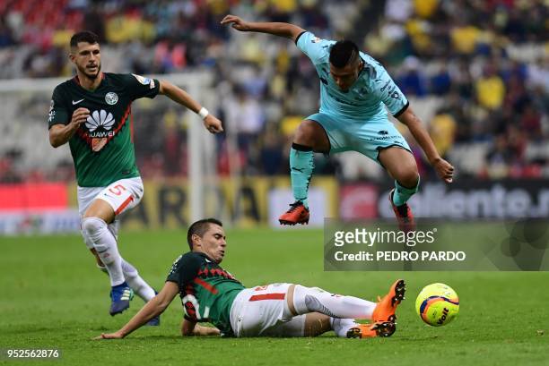 Santos midfielder Osvaldo Martinez vies for the ball with America's defender Paul Aguilar during their Mexican Clausura tournament football match at...