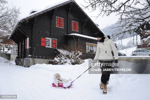 Mother and daughter sledding, Morzine ski resort, Portes du Soleil skiing area, region of Chablais, Haute-Savoie department, Rhone-Alpes region,...