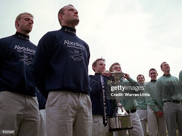 Coxes Jeremy Moncrieff of Oxford and Christain A Cormack of Cambridge hold the trophy as they are surrounded by the teams during the Presidents...