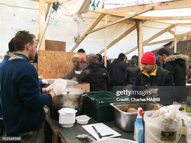 Bénévoles distribuant de la nourriture, camp de réfugiés, le 16 février 2016, Dunkerque, France.