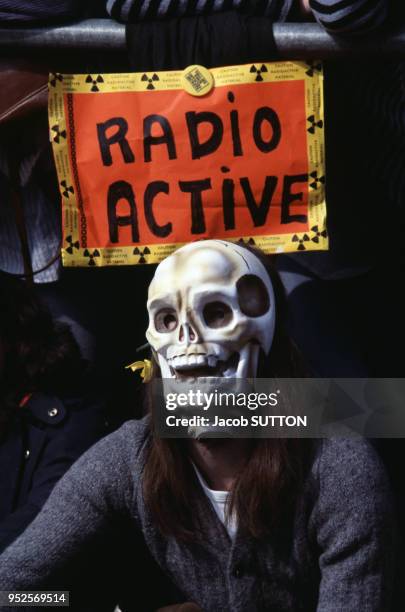 Jeune femme portant un masque de tête de mort et panneau anti-nucléaire lors d'une manifestation pacifiste, circa 1980, Royaume-Uni.