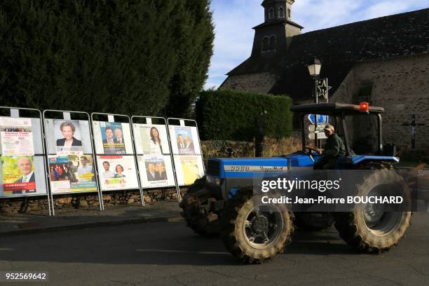 Un agriculteur circulant avec son tracteur devant les ffiches électorales des élections régionales 2015 pour la région Aquitaine Limousin...