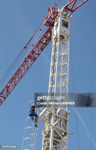 Chantier de construction de l'autoroute A89 sur le reseau d'Autoroute du Sud de la France . Le grutier doit souvent commencer par gravir une immense...