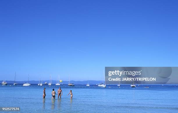 Touristes jouant au ballon et bateaux de plaisance au mouillage, Plage d'Argent, Ile de Porquerolles, Iles d'Hyères, Var, région Provence-Alpes-Côte...