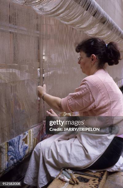 Velouteuse au travail sur un metier de haute-lisse, tapis de savonnerie, tapisserie, Manufacture Saint-Jean, Aubusson, departement Creuse, region...