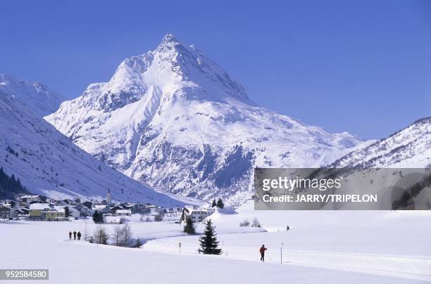 Skieurs de fond, la montagne Ballunspitze -2671 m- en arriere plan du village de Galtur, la riviere Trisanna, vallee de Paznaun, Silvretta region du...