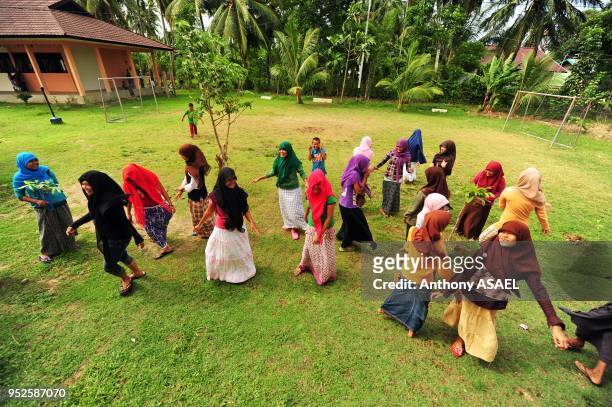 Adolescents dancing in school yard, Banda Aceh, Sumatra, Indonesia.