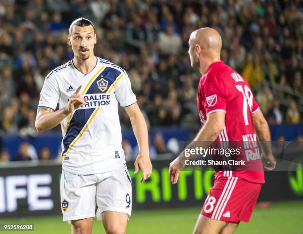 Zlatan Ibrahimovic of Los Angeles Galaxy talks to Aurelien Collin of New York Red Bulls durig the Los Angeles Galaxy's MLS match against New York Red...