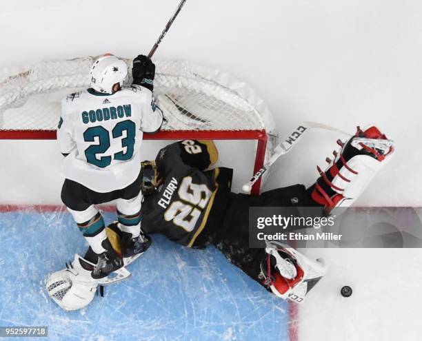 Barclay Goodrow of the San Jose Sharks jumps on the crossbar over Marc-Andre Fleury of the Vegas Golden Knights after Fleury blocked his shot in the...